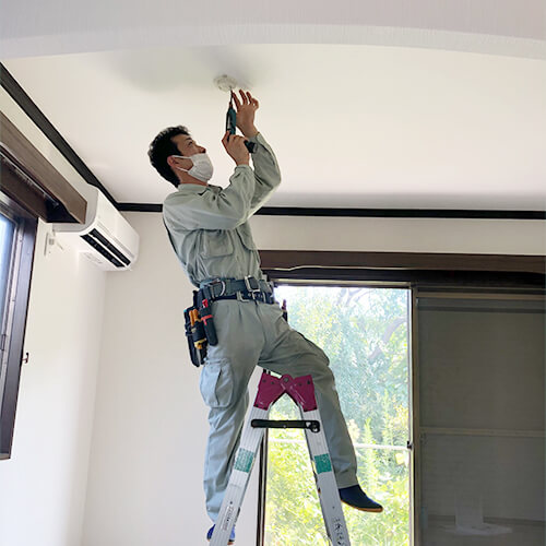 照明器具を取り付ける信和の職人
